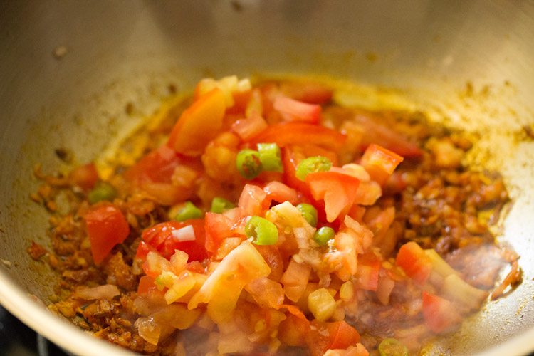 chopped tomatoes and chopped green chili added to the pan. 