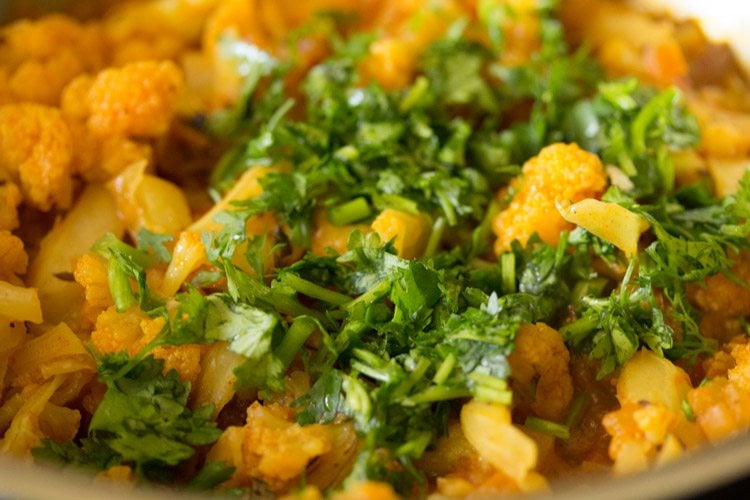 chopped coriander leaves added to cooked cauliflower curry. 