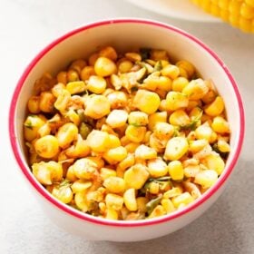 corn salsa served in a dark pink rimmed white bowl