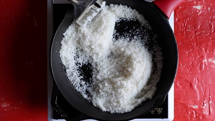 stirring desiccated coconut in skillet