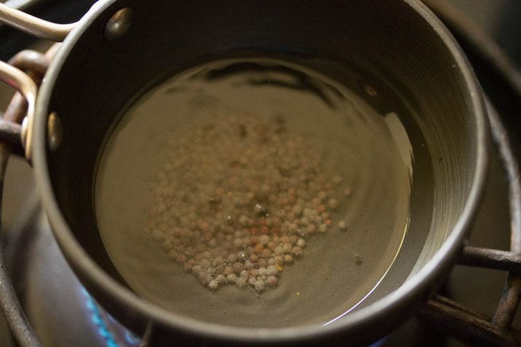 mustard seeds added to melted coconut oil in the pan. 