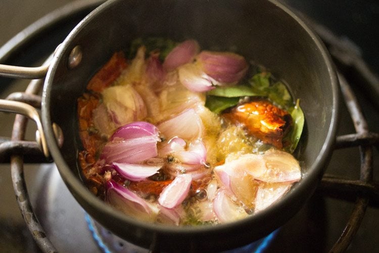 thinly sliced pearl onions added to hot coconut oil. 