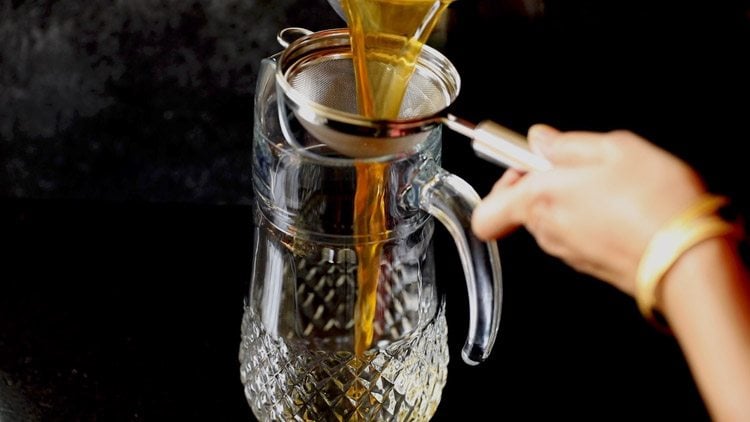 straining lemon iced tea.