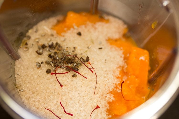 sugar, saffron and cardamom seeds added to the mangoes in the blender jar. 