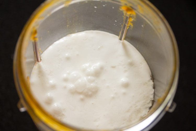 adding coconut milk to mango puree.