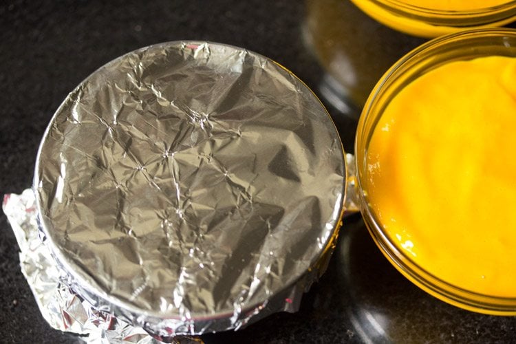 covering mango pudding in bowls with foil.