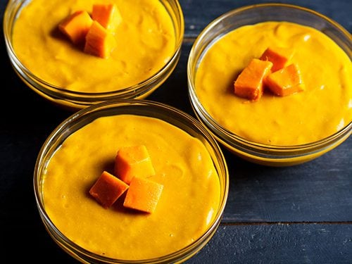 mango pudding in 3 glass bowl with three mango cubes in center