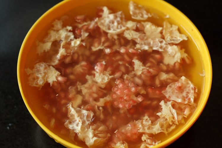 pith floating at the top of the bowl of water and arils