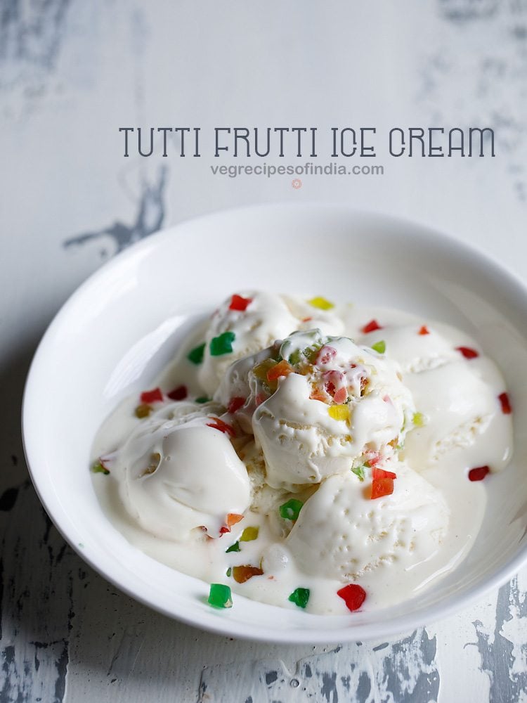 tutti frutti ice cream scoops garnished with tutti frutti and served in a white bowl.
