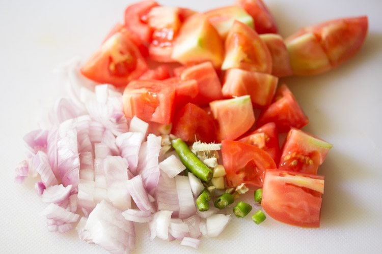 chopping onion, tomatoes, ginger, garlic, green chilies