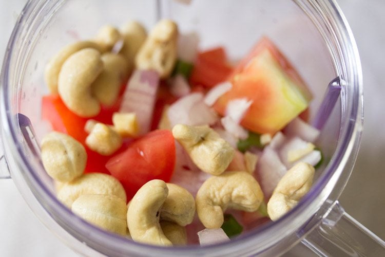 chopped ingredients and cashewnuts in blender jar