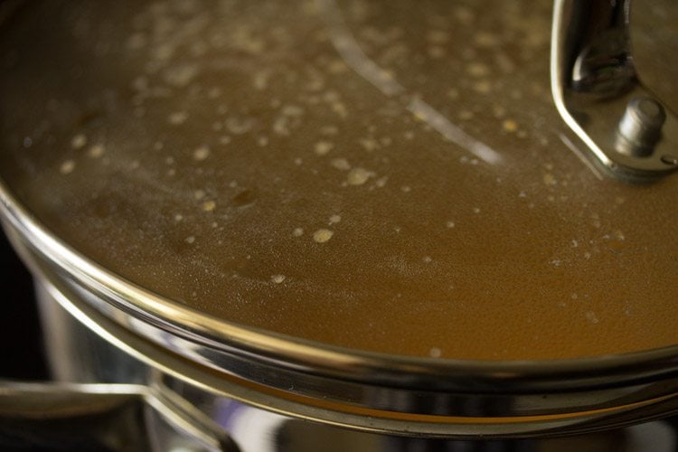 covering the pan with a lid to avoid spluttering of paste