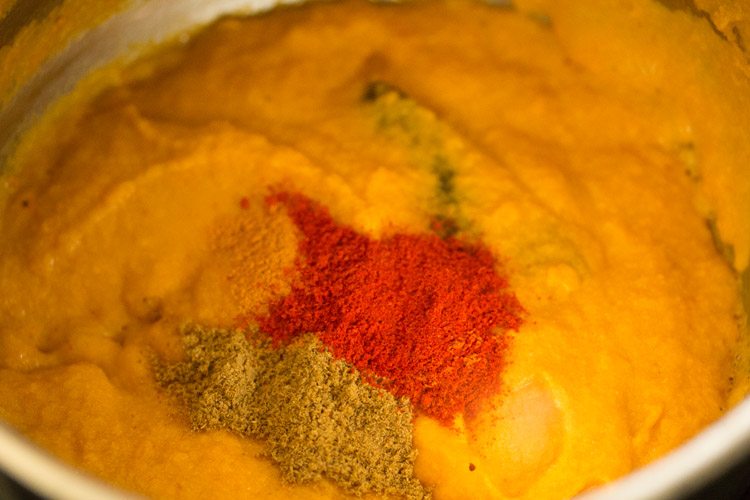 adding spices in paste - turmeric powder, coriander powder, kashmiri red chili powder