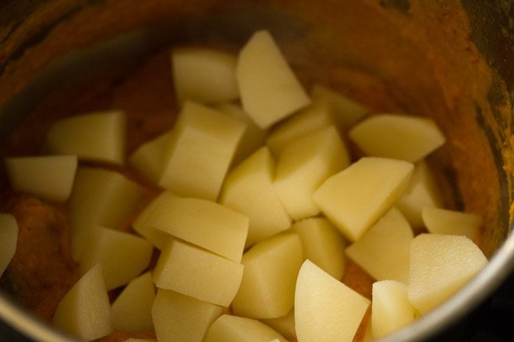 adding chopped potatoes in pan