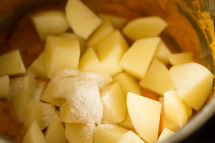 adding salt to potatoes in pan