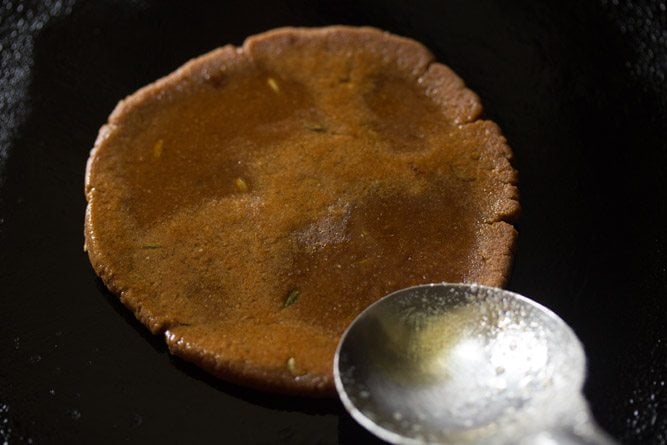 applying ghee on gur ki roti