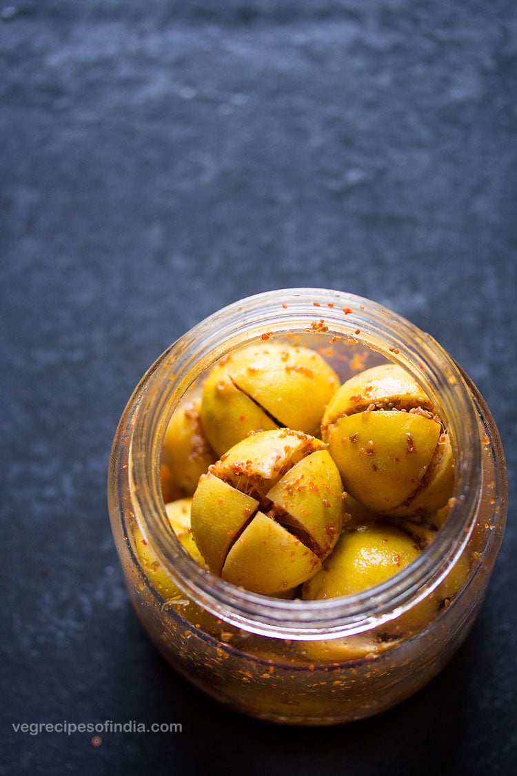 lemon pickle in a glass jar on a blue board