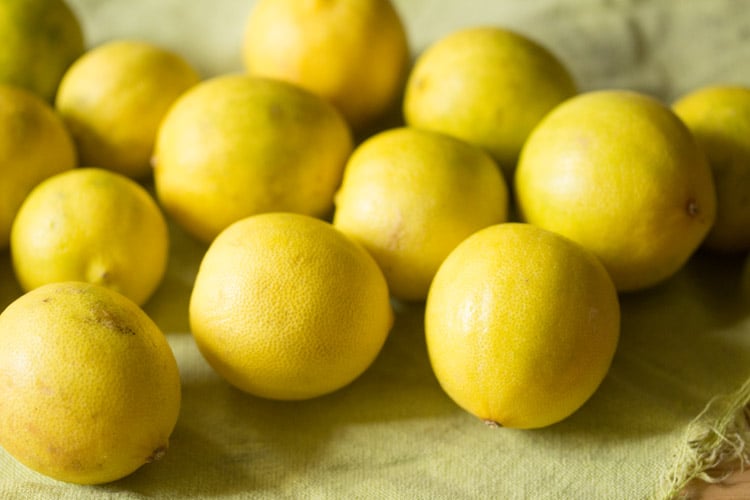 rinsed and dried fresh yellow lemons on a kitchen napkin