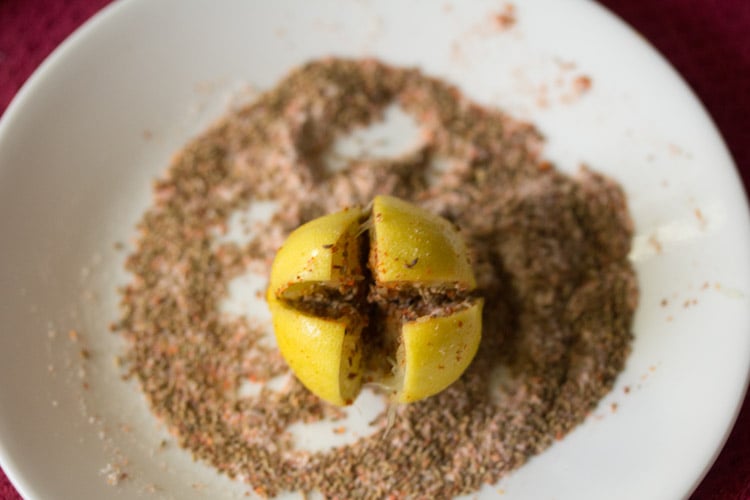 spice and salt mixture stuffed inside an almost cut lemon