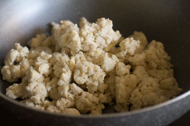 crumbled khoya in a pan on heat.