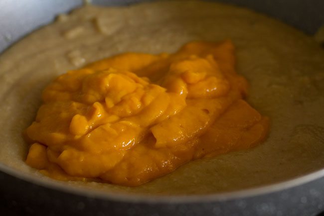 prepared mango pulp added to the khoya-sugar mixture in the pan. 
