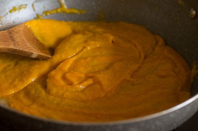 stirring the mango-khoya mixture in the pan. 