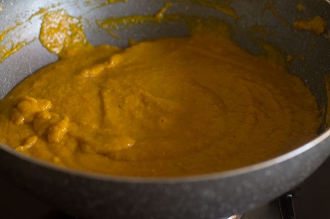 cooking the mango-khoya mixture in the pan. 