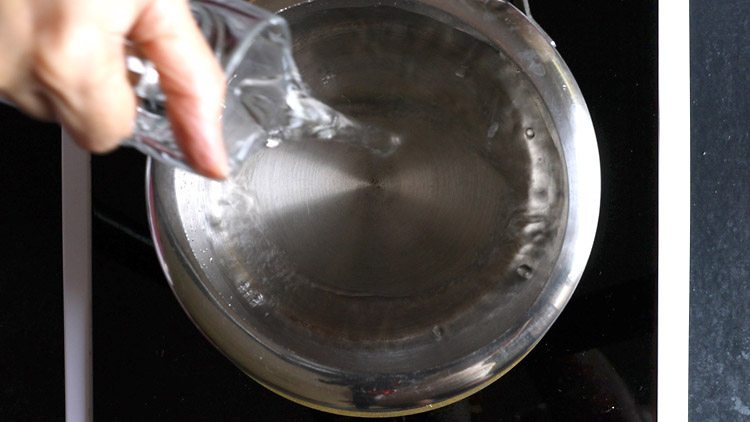 adding water to a pan.