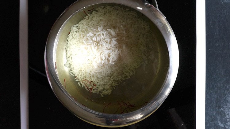 rice added to saffron water for making meethe chawal recipe.