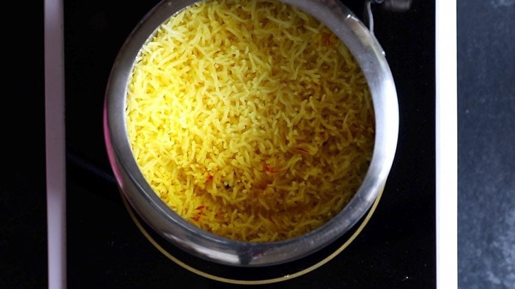 making zarda pulao recipe and the rice is now al dente and bright yellow.