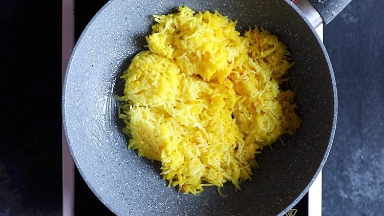 adding rice to pan for making meethe chawal recipe.