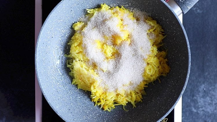 adding sugar to the zarda pulao recipe.