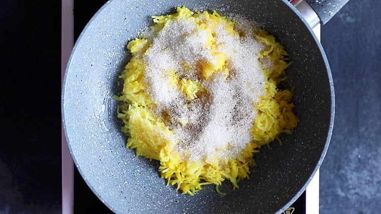 sprinkling cardamom on the zarda rice.