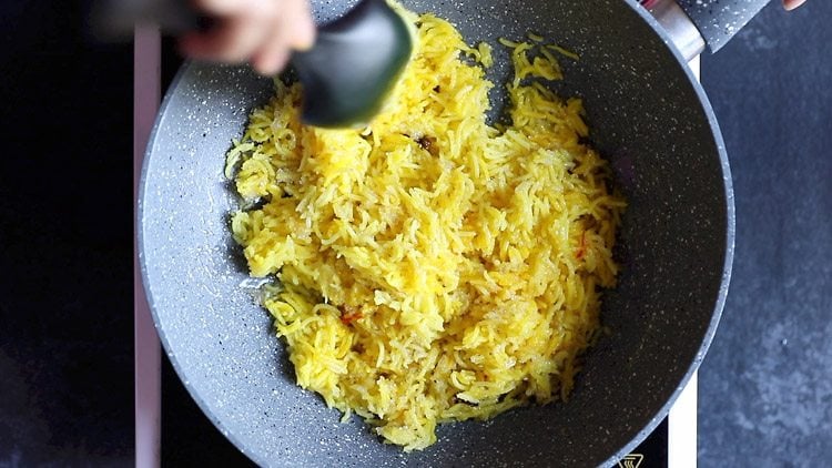 mixing the zarda pulao together.