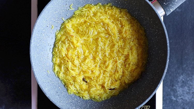 liquid is emerging from the grains of rice as it cooks in the ghee.