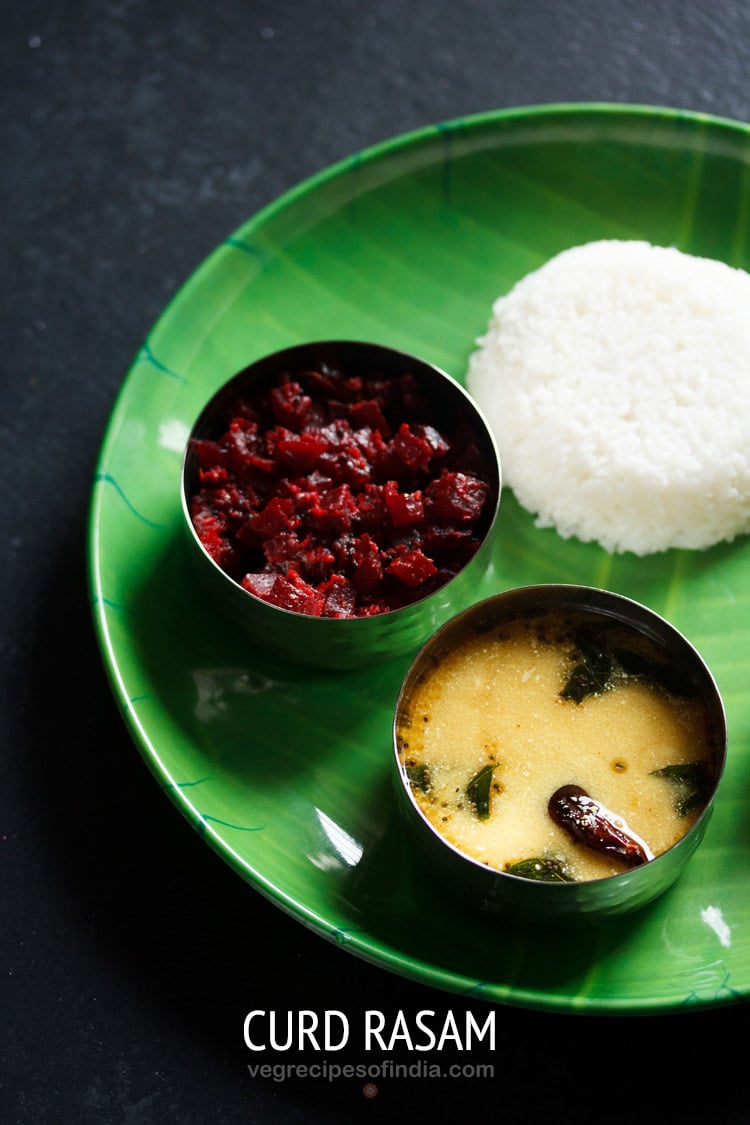 majjige saaru served in a bowl placed on a green plate with steamed rice and beetroot poriyal and text layover.