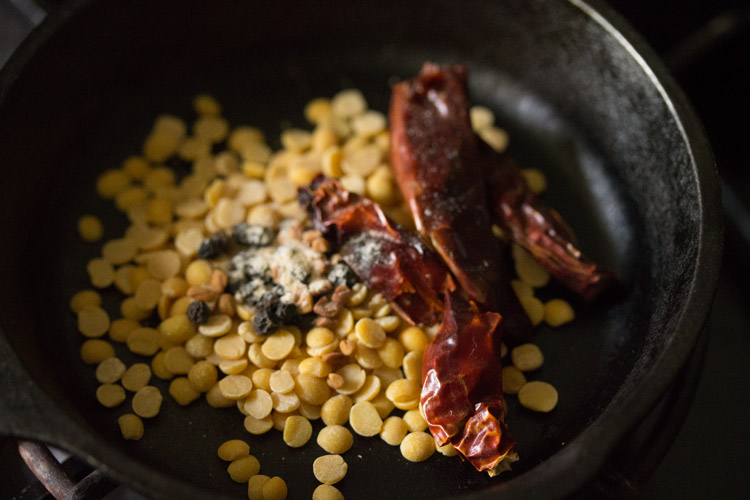 dried red chilies, black peppercorns, fenugreek seeds and asafoetida added to pan. 