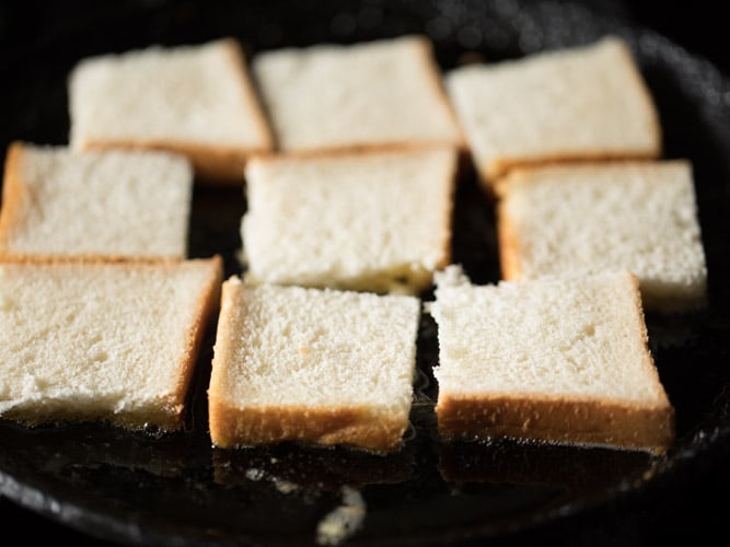 toasting bread pieces in hot ghee on a pan for making double ka meetha recipe. 