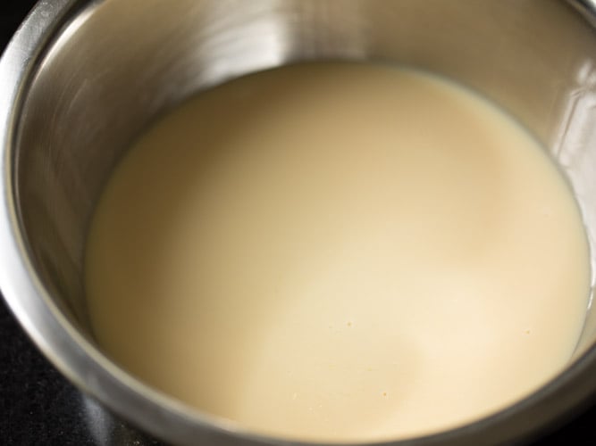 sweetened condensed milk added in a bowl for making double ka meetha recipe. 