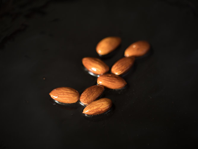 almonds added to hot ghee in pan. 