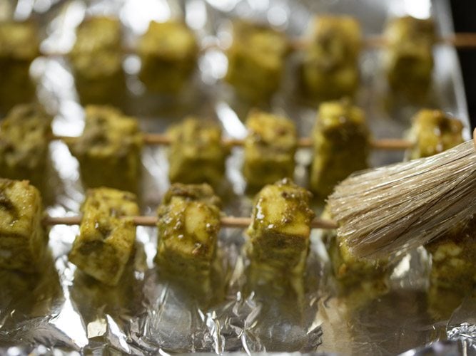 brushing paneer tikka with some oil. 