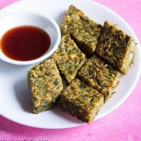 kothimbir vadi served on a white plate with a small bowl of chutney on the side.