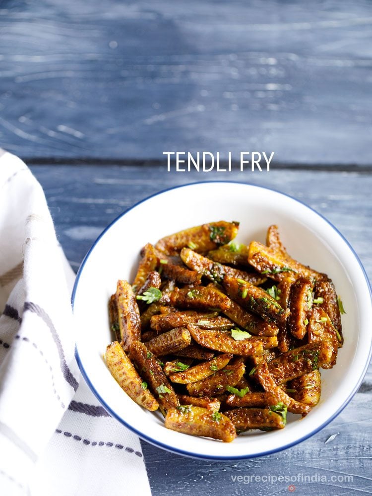 dondakaya fry garnished with coriander leaves and served in a white bowl with text layover. 