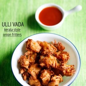 ulli vada served in a blue rimmed white plate with a small bowl of tomato ketchup kept on the top right side and text layovers.
