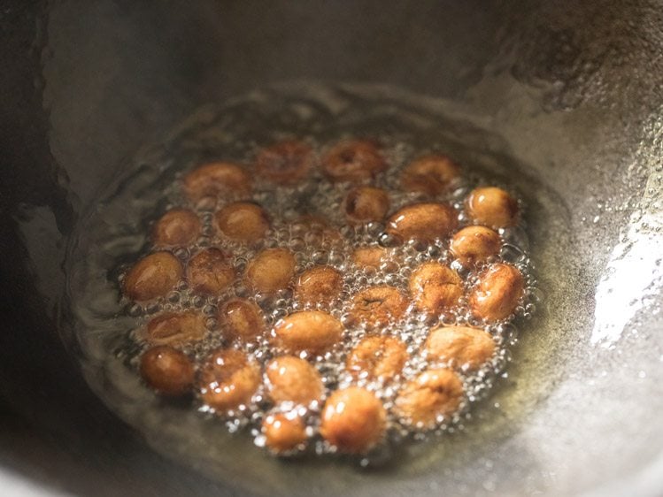 frying raisins till they swell for poha kheer. 