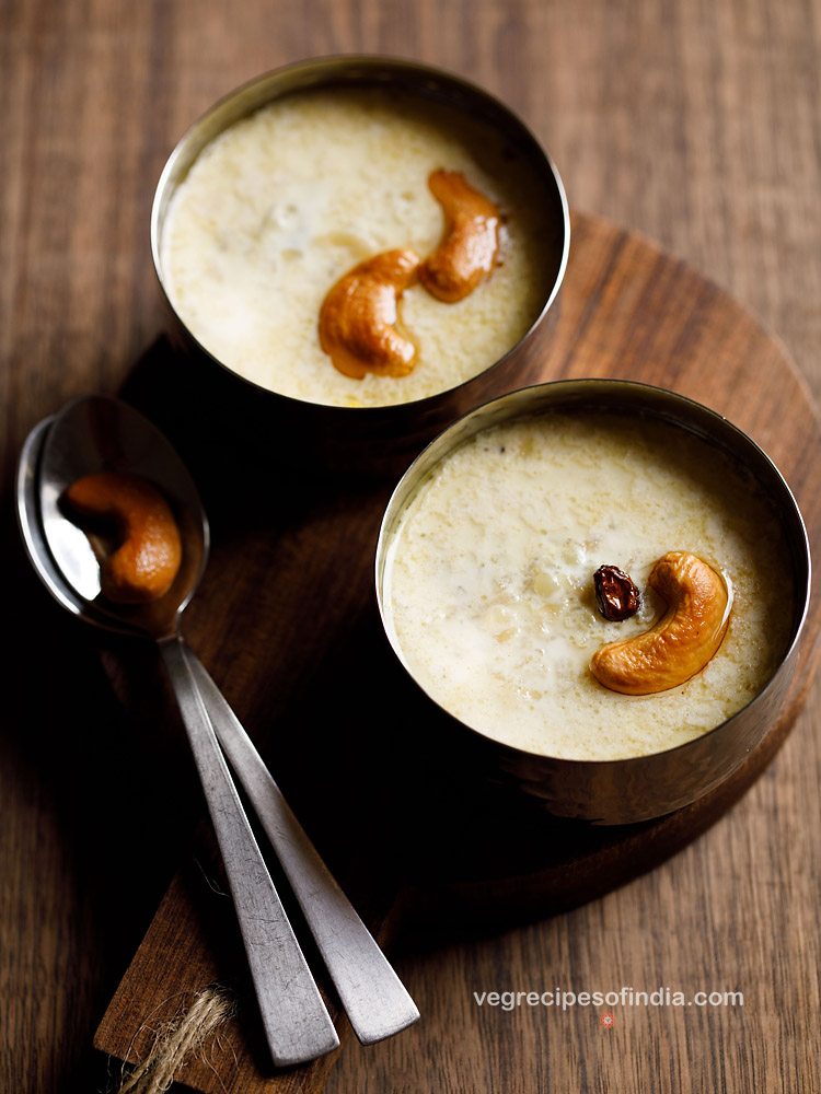 aval payasam garnished with fried cashews and raisin and served in 2 bowls with a fried cashew kept on a spoon on the left side and text layover. 