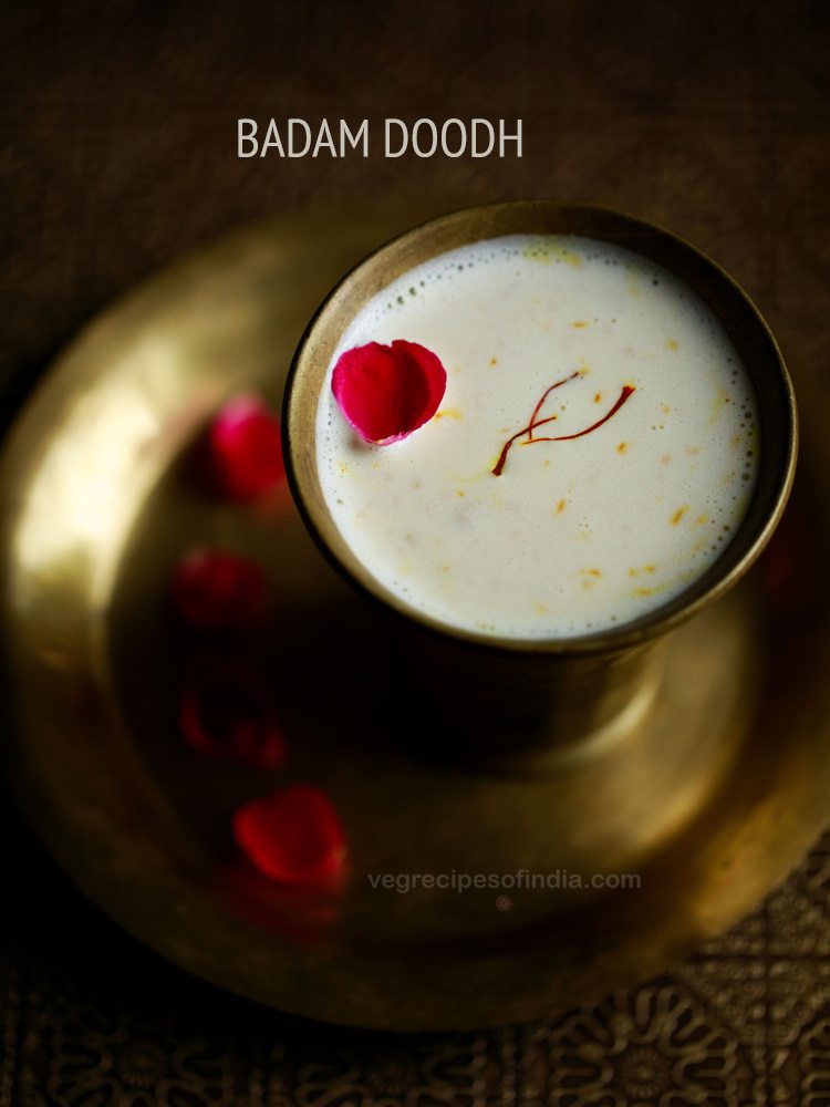 badam milk in a copper glass garnished with a rose petal and 3 saffron threads.