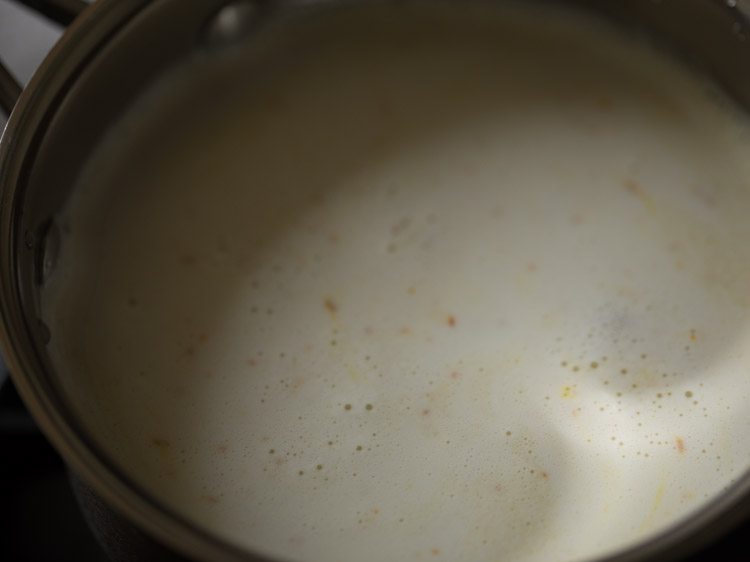 warming badam milk in a saucepan.