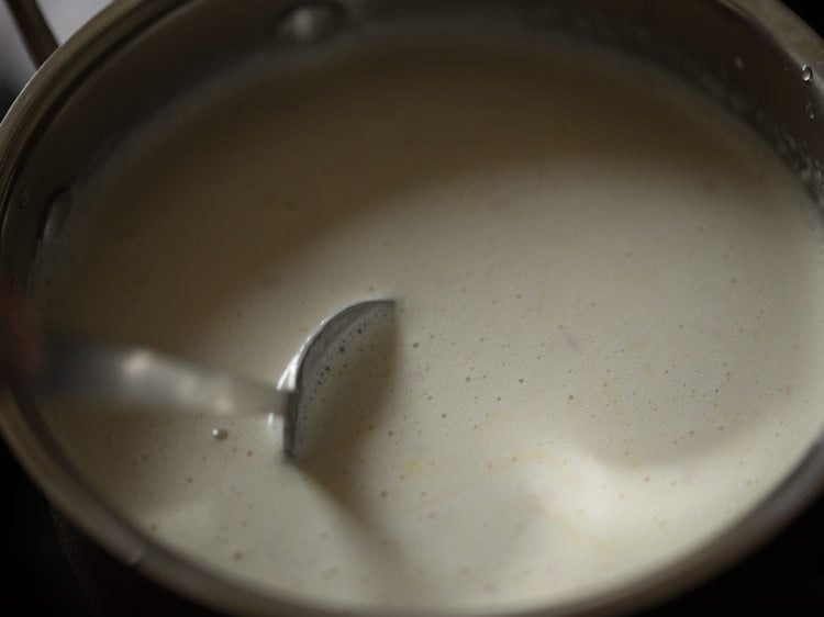 stirring badam milk to keep from scorching.