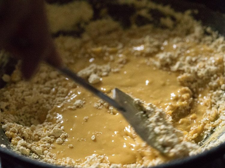 mixing besan with the ghee for besan barfi recipe. 